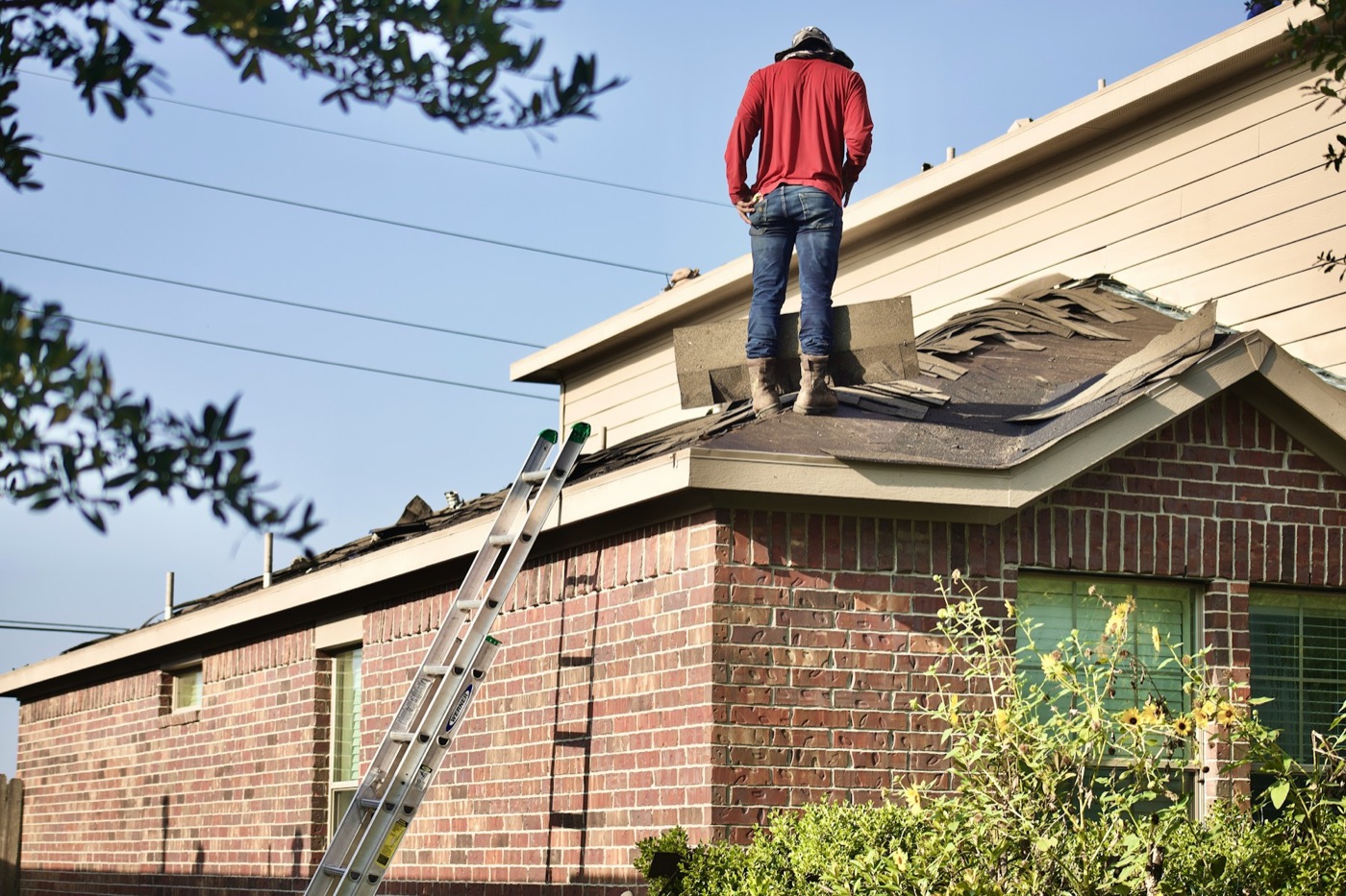 Roofing professional inspecting a residential property